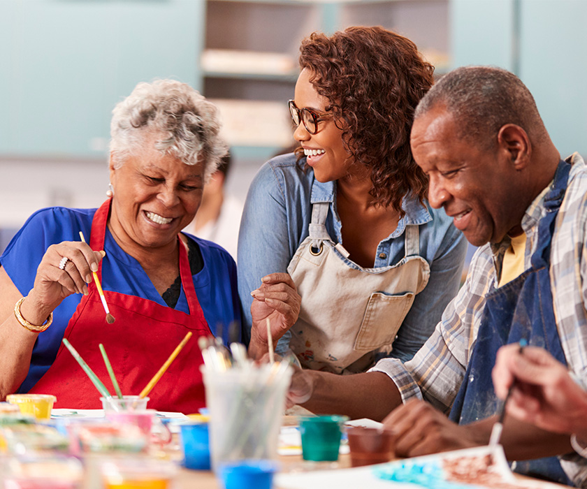 Residents painting together in community art with an instructor.