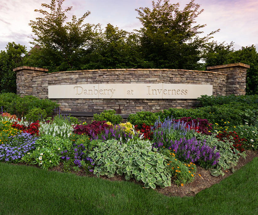 Entrance sign with vibrant flower beds at Danberry at Inverness.