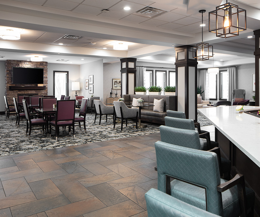 Spacious senior living community lounge with seating and modern decor.