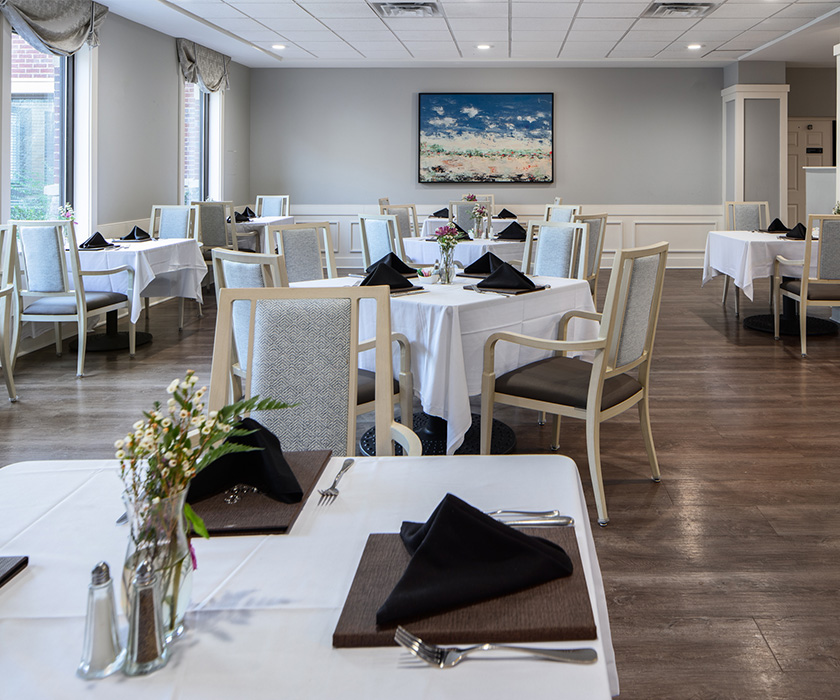 Elegant dining area with neatly set tables in a senior living community.