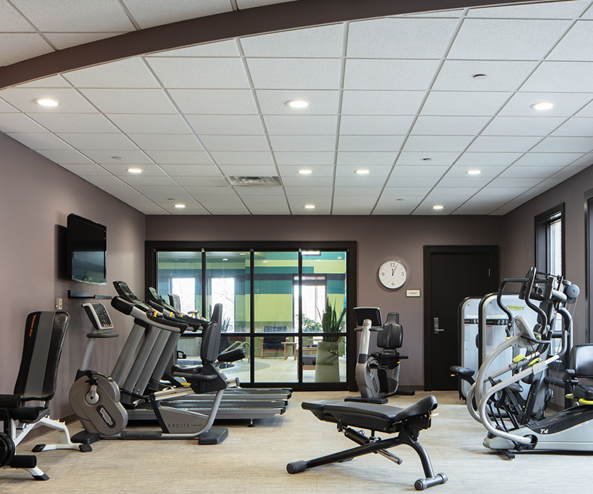 Exercise room with treadmills, stationary bikes, and strength equipment.