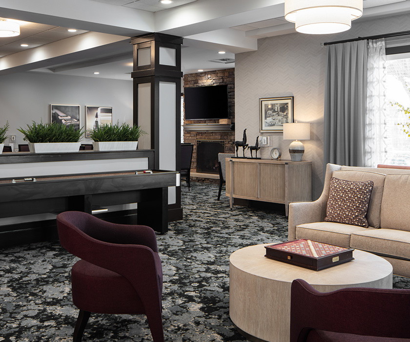 Elegant lounge area with modern furniture, plants, and a fireplace.