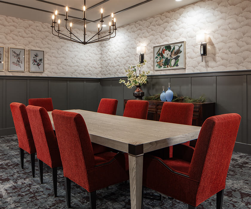 Elegant dining area in a unit with red chairs and modern chandelier.