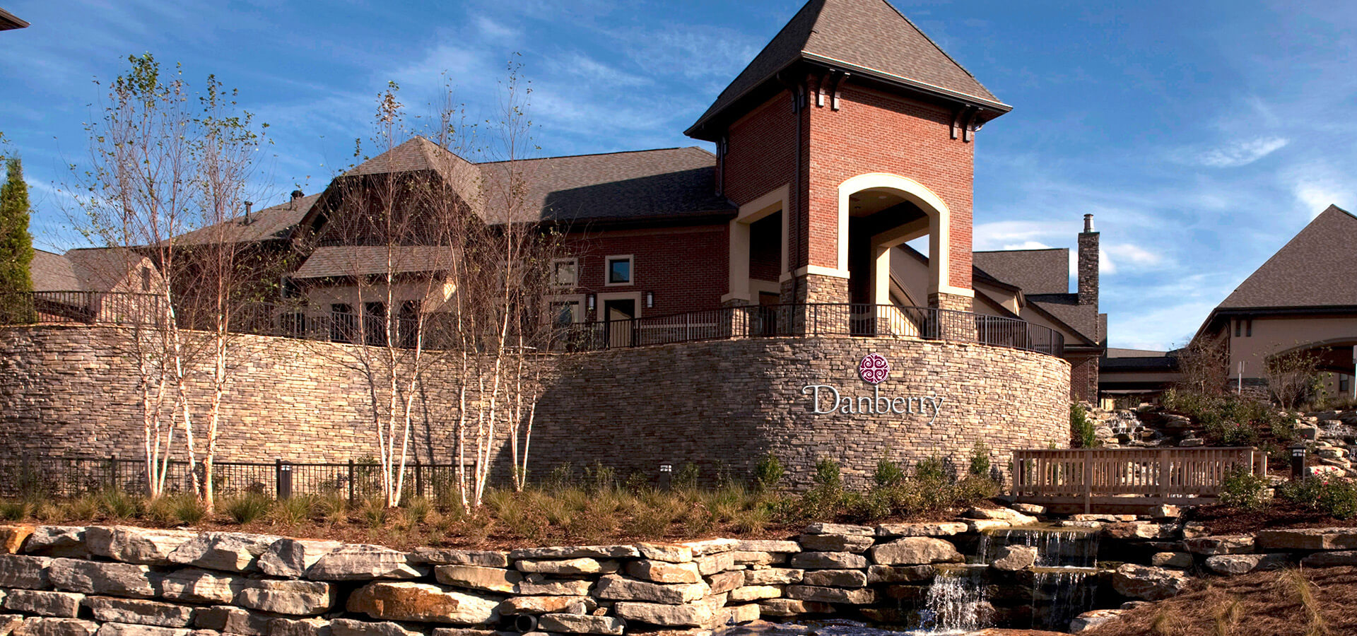 Elegant senior living building with brick facade and landscaped garden.